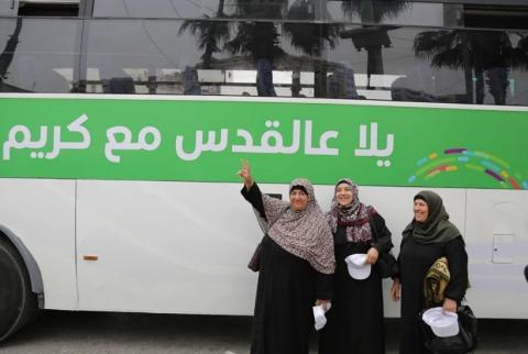 مواطنات أمام حافلة "كريم" قبل نقلهن إلى حاجز قلنديا ’كريم’ تختتم مبادرتها الخيرية لنقل المواطنين إلى حاجز قلنديا مجانا