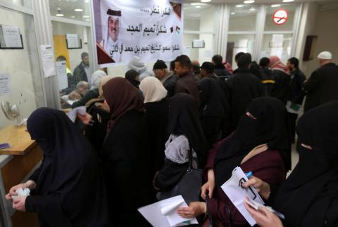 موظفون فلسطينيون مُعينون من قبل حماس ينتظرون لصرف رواتبهم المقدمة من قطر في خان يونس يوم الجمعة. تصوير: إبراهيم أبو مصطفى - رويترز. قطر تدفع أجور موظفي غزة المدنيين