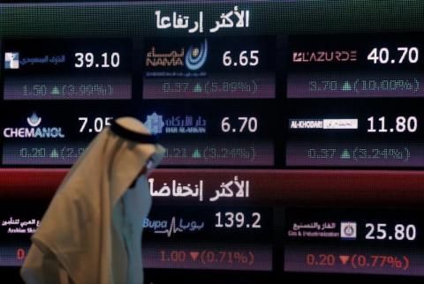 شاشة الكترونية تعرض أسعار أسهم بالبورصة السعودية في الرياض - صورة من أرشيف رويترز. أسهم بنوك السعودية تهوي بسبب مدفوعات الزكاة وخسائر أمريكا تضغط على الخليج