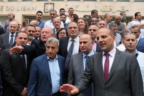 موظفون بمصرف لبنان المركزي يتجمعون خلال اضراب أمام المصرف في بيروت يوم 5 مايو ايار 2019. تصوير: محمد عزاقير - رويترز. موظفو مصرف لبنان يقررون تعليق الإضراب حتى الجمعة