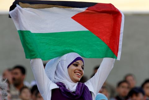 صورة توضيحية-شابة ترفع العلم الفلسطيني-أرشيف وكالات 13 مليونا تعداد الفلسطينيين في العالم