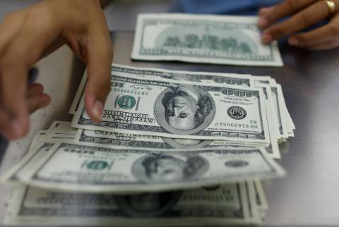 أوراق نقدية من عملة الدولار الأمريكي-تصوير رويترز رهانات النمو الأمريكي تدفع الدولار للتحليق قرب ذروة عدة أشهر