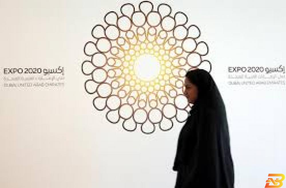 امرأة تمر أمام شعار معرض إكسبو 2020 في دبي - صورة من أرشيف رويترز إكسبو 2020 دبي: 190 دولة تؤكد مشاركتها في المعرض العالمي